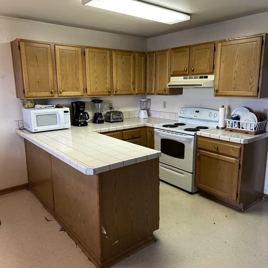 Before: A Fair Lakes kitchen stuck in the 90s — an awkward angled peninsula, worn tile counters, and peeling vinyl floors made the room feel smaller every year.